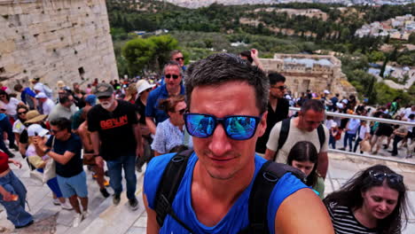 Excited-tanned-man-explore-the-Monument-of-Agrippa,-selfie-closeup-on-swarm-stairs-of-Acropolis