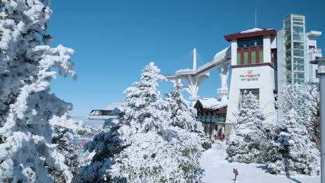 Snowcapped-Monapark-and-Cable-Car-Building-Facade-at-Yong-Pyong-Ski-Resort-at-Balwangsan-Mountain-Summit-on-Sunny-Day,-Pyeongchang-gun,-Gangwon-do-South-Korea---reveal-parallax