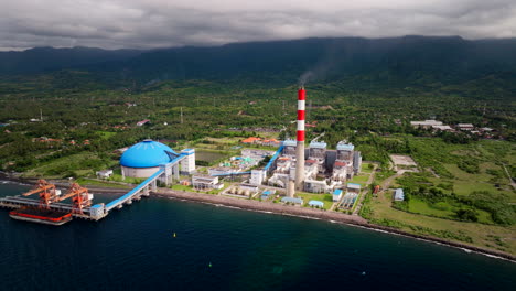 Burning-red-and-white-smokestack-of-coal-power-plant-on-Bali-coastline