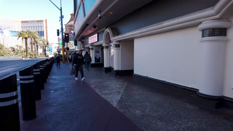 Fußgänger-Entlang-Der-Strip-Street-In-Las-Vegas-Mit-Palmen-Und-Ikonischer-Stadtarchitektur
