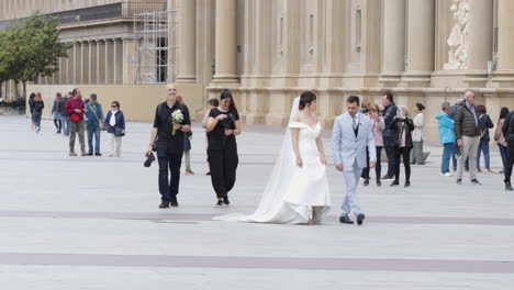 Bride-And-Groom-Walking-At-The-Plaza-Of-Our-Lady-of-the-Pillar-In-Zaragoza,-Spain