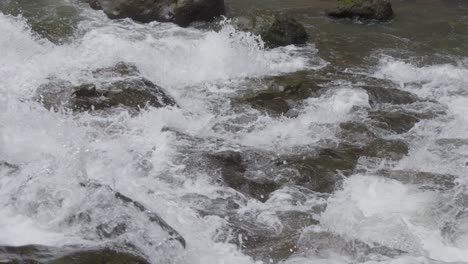 Close-up-of-water-cascading-over-the-rocks-of-Goa-Rang-Reng-Waterfall-on-Bali-island