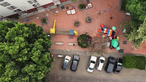 Slow-motion-aerial-view-of-children-playing-ball-in-a-playground