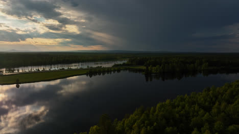 Luftaufnahme-Eines-Dramatischen-Regnerischen-Abends-Mit-Sonnenschein,-Einer-Brücke-Und-Reflektierenden-Seen-Lapplands