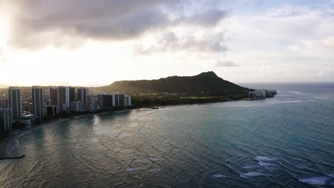 Drone-shot-of-Oahu's-calm-waters-surrounding-Diamond-Head-at-sunset