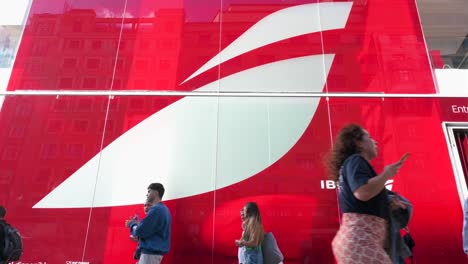 A-low-angle-view-of-pedestrians-walking-past-Iberia's-pop-up-store-on-the-retail-and-entertainment-street-of-Gran-Via-in-Madrid,-Spain