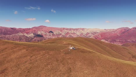 Luftaufnahme-Eines-Aufsteigenden-Berges,-Die-Den-Cerro-De-Los-14-Colores-Hinter-Einem-Berg-Enthüllt