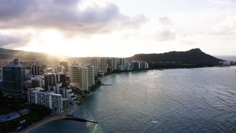 Toma-De-Drones-De-La-Densa-Costa-De-Oahu-Al-Atardecer-Con-Una-Cabeza-De-Diamante-Prominente-En-La-Distancia