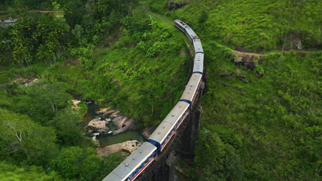 Drohne-Neigt-Sich-Tief-über-Einen-Zug,-Der-Eine-Kleine-Brücke-In-Sri-Lanka,-Asien-Passiert