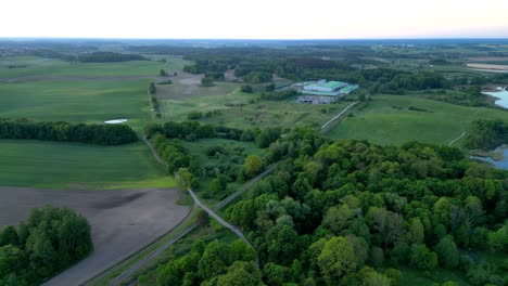 Panorama,-Drohnenansicht-Des-Waldes,-Der-Ein-Kleines-Dorf-Umgibt