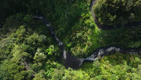Scenic-calm-river-and-waterfall-cascades-across-tropical-Hawaiian-jungle-along-road-to-hana