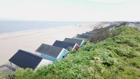 Seaside-view-with-family-beach-huts-from-coastal-sand-dune-grasses-Southwold
