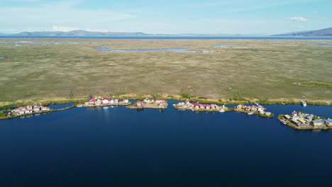 Coastal-village-floating-home-of-Uros-people-in-Bolivia-on-shore-edge,-aerial