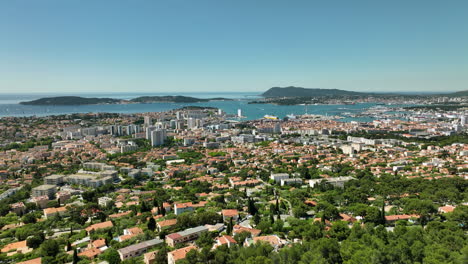 Toulon-cityscape-with-lush-greenery,-blue-sea,-and-clear-sky,-aerial-view