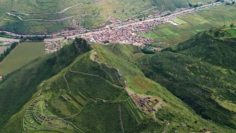 Genießen-Sie-Von-Oben-Eine-Atemberaubende-Aussicht-Auf-Die-Antiken-Ruinen-Von-Pisac,-Das-Charmante-Dorf-Und-Die-Straßen,-Die-Nach-Cusco-Führen