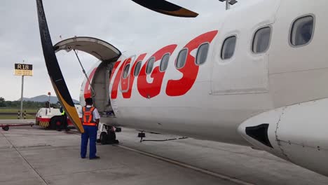 Ein-Offizier-überprüft-Die-Flugvorbereitungen-Für-Ein-Flugzeug-Vom-Typ-Wings-Air-ATR-72-Am-Sultan-Hasanuddin-International-Airport,-Makassar,-Indonesien