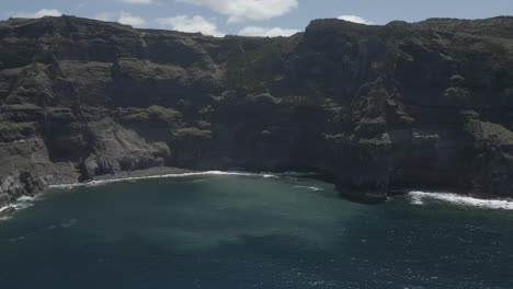 Atemberaubende-Luftaufnahme-Der-Klippen-Von-Ponta-Da-Ferraria-Und-Der-Meereswellen-An-Einem-Sonnigen-Tag