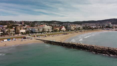 Küste-Von-Sitges-Mit-Stadtgebäuden,-Stränden-Und-Klarem-Blauen-Wasser,-Luftaufnahme