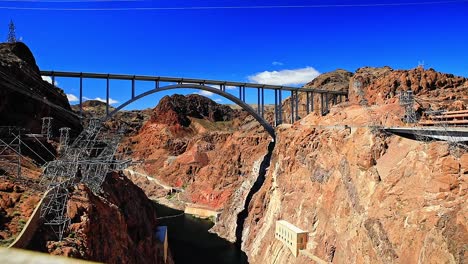 Puente-De-La-Presa-Hoover-Entre-El-Cañón-En-Un-Día-Soleado-Con-Cielos-Azules,-Plano-Amplio,-Nevada,-Estados-Unidos