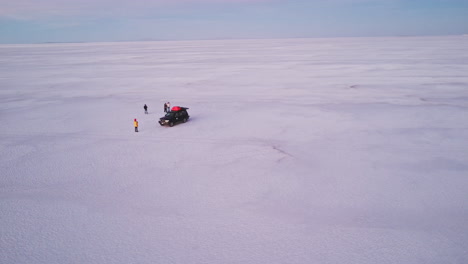 Eine-Gruppe-Von-Freunden-Spielt-Zusammen-In-Der-Sauberen,-Trockenen,-Weißen-Landschaft-Der-Salzebenen,-Bolivien