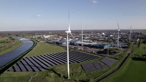 Windturbinen-Und-Solarmodule-Für-Saubere-Energie-In-Den-Niederlanden,-Langsamer-Luftschwenk-An-Einem-Sonnigen-Tag