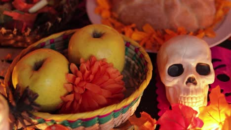 Apple-and-bread-offering-and-skull-decorations-on-Día-de-muertos-altar