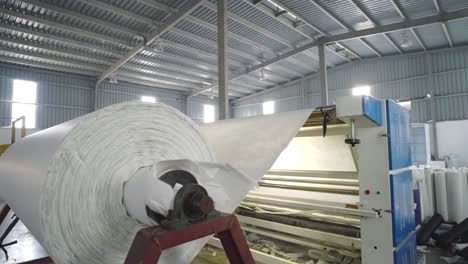White-Textile-Fabric-Being-Rolled-In-Factory