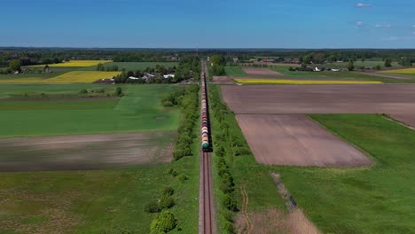 A-Russian-freight-train-travels-through-the-countryside-in-Lithuania,-aerial-view