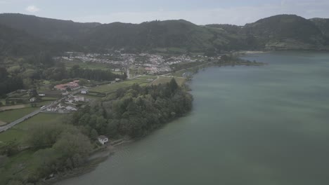 Scenic-aerial-view-of-Sete-Cidades-village-by-the-lakes-in-Portugal-surrounded-by-lush-green-hills