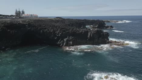 Dramatic-coastal-cliffs-and-ocean-waves-at-Ponta-da-Ferraria-during-daytime,-aerial-view