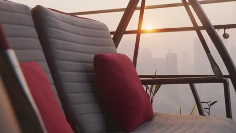 Throw-Pillows-On-a-Swing-Chair-With-A-City-Landscape-View-At-Dusk