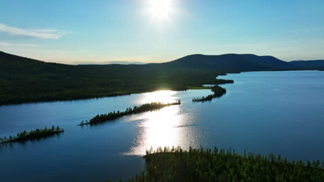 Aerial-view-circling-islands-on-lake-Pallasjarvi,-with-fells-in-the-background