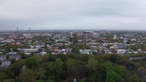 Aerial-wide-rising-shot-of-Forsyth-Park-towards-downtown-Savannah,-Georgia