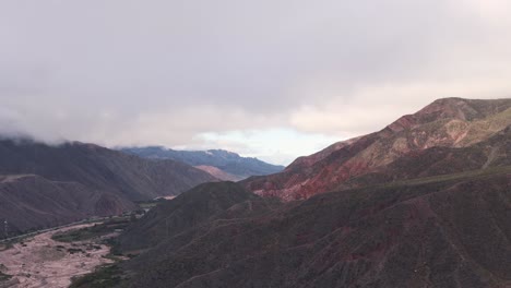 Drohne-Steigt-In-Die-Wolken-Und-Zeigt-Die-Trockene-Und-Bergige-Landschaft-Im-Norden-Argentiniens,-Route-9,-Jujuy