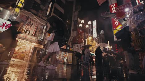 Gente-En-Las-Calles-Mojadas-Durante-La-Noche-Lluviosa-En-El-Centro-Comercial-De-Osaka-En-Japón
