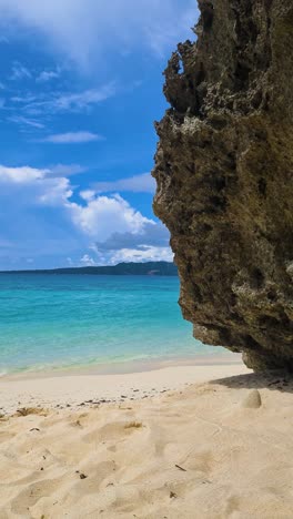 Vertical-Video,-Tropical-Beach,-White-Sand,-Rock-and-Turquoise-Sea-on-Hot-Sunny-Day