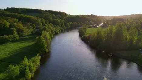 Aerial-drone-backward-over-bridge-crossing-Vienne-River,-Saint-Victurnien,-Nouvelle-Aquitaine-in-France