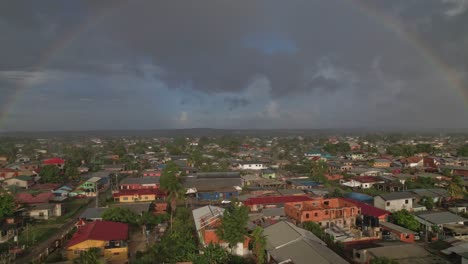 Drone-Flying-Over-Village-Towards-Rainbow