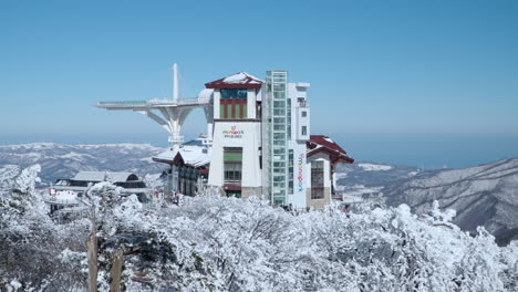 Monapark-Cable-Car-Building-Against-Blue-Sky-at-Yong-Pyong-Ski-Resort-at-Balwangsan-Mountain-Summit,-Pyeongchang-gun,-Gangwon-do---aerial-pan