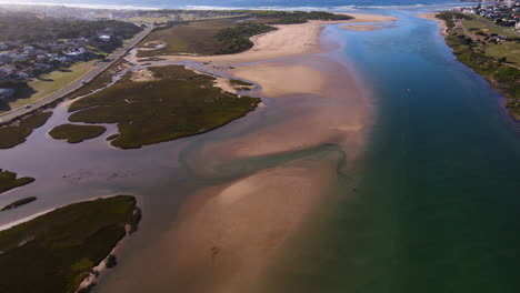 Drone-flight-over-Goukou-estuary-shows-clear-water-and-sand-banks,-Still-Bay