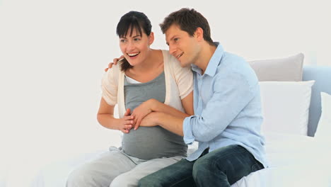Couple-feeling-movements-of-their-future-baby-
