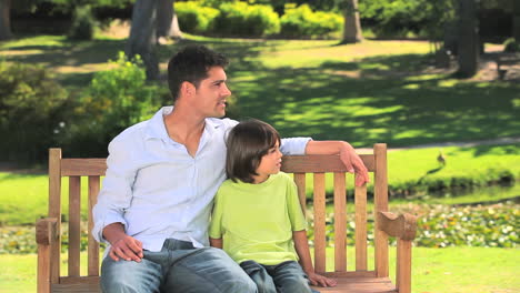 Father-sitting-with-his-son-on-a-park-bench-
