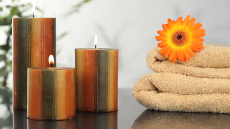 Close-up-on-candles,-towels-and-sunflower-
