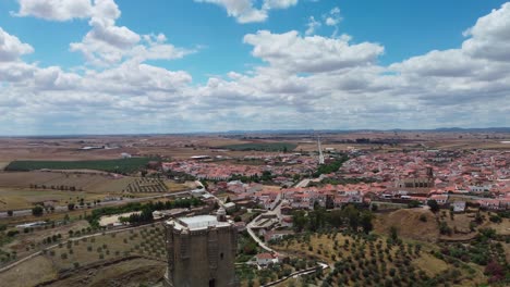 Belalcazar-castle-in-cordoba-spain-with-a-sprawling-townscape-under-a-blue-sky,-aerial-view