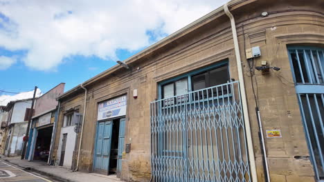 A-view-of-a-historic-building-in-Nicosia,-Cyprus,-with-blue-shutters-and-gates