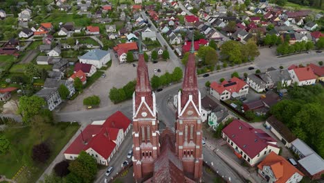 Flyway-church-in-lithuania-with-surrounding-village-in-spring,-aerial-view
