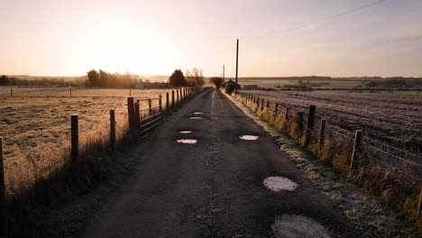 Goldener-Sonnenaufgang-Entlang-Einer-Unbefestigten-Straße-In-Einer-Ländlichen-Gegend-Von-Schottland-Im-Winter-In-Perth-Shire,-Großbritannien