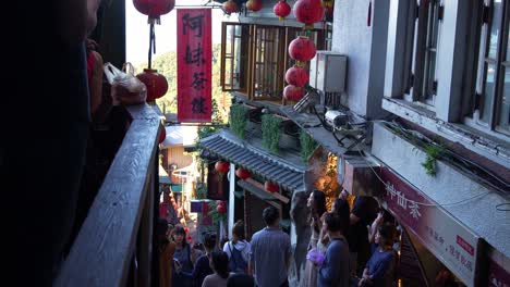 People-climbing-up-the-narrow-stairs-of-Jiufen-Old-Street-with-A-Mei-teahouse-heritage-building-in-the-background,-a-gold-mining-mountain-town,-popular-tourist-attraction-in-Taiwan