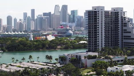 Drone-tilting-over-islands-toward-a-cruise-liner-and-the-Miami-skyline-in-USA