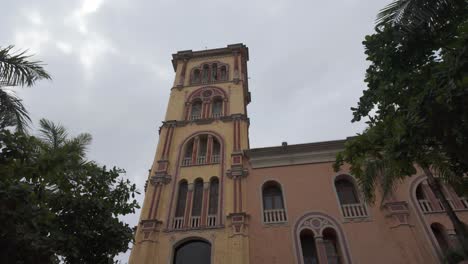 Edificio-Histórico-De-La-Universidad-En-Cartagena,-Colombia,-Con-Una-Fachada-Rosa-Y-Palmeras-A-La-Vista